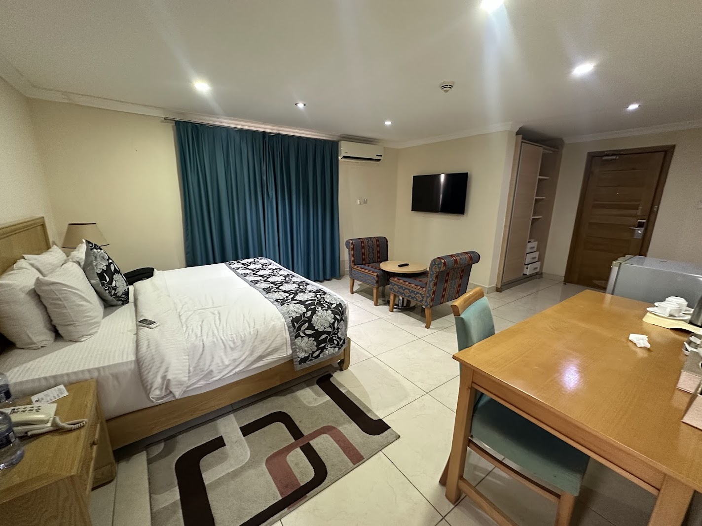 Spacious deluxe room with a king bed, lounge chairs and work desk