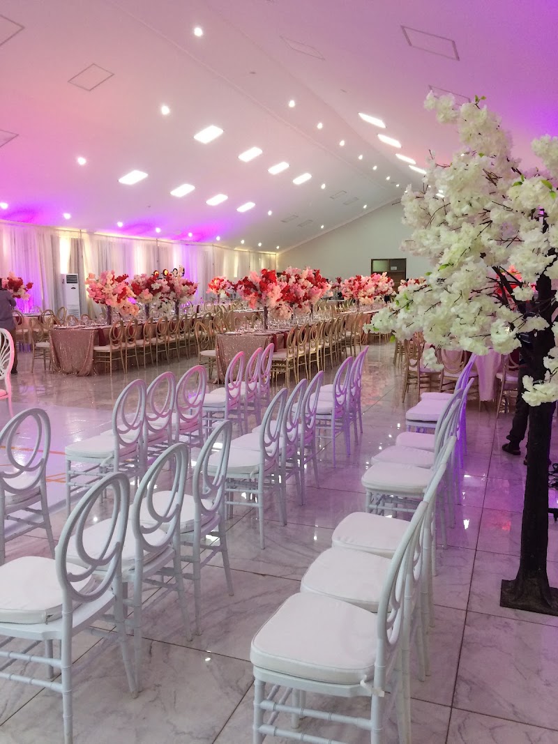 The Ofosua Banquet Hall dressed for a wedding, with floral arrangements and chiavari chairs