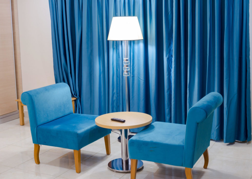 A quiet lounge corner with armchairs and a reading lamp